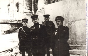 И.В. Малышев (второй слева) с однополчанами у здания Рейхстага в Берлине. Его рукой на стене Рейхстага написано: «Мы Волгари из Саратова и Костромы». Май 1945